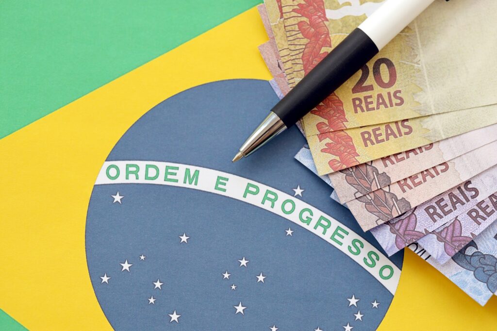 Pen with Brazilian money bills on blank of lottery game. Concept of luck and gambling in Brazil