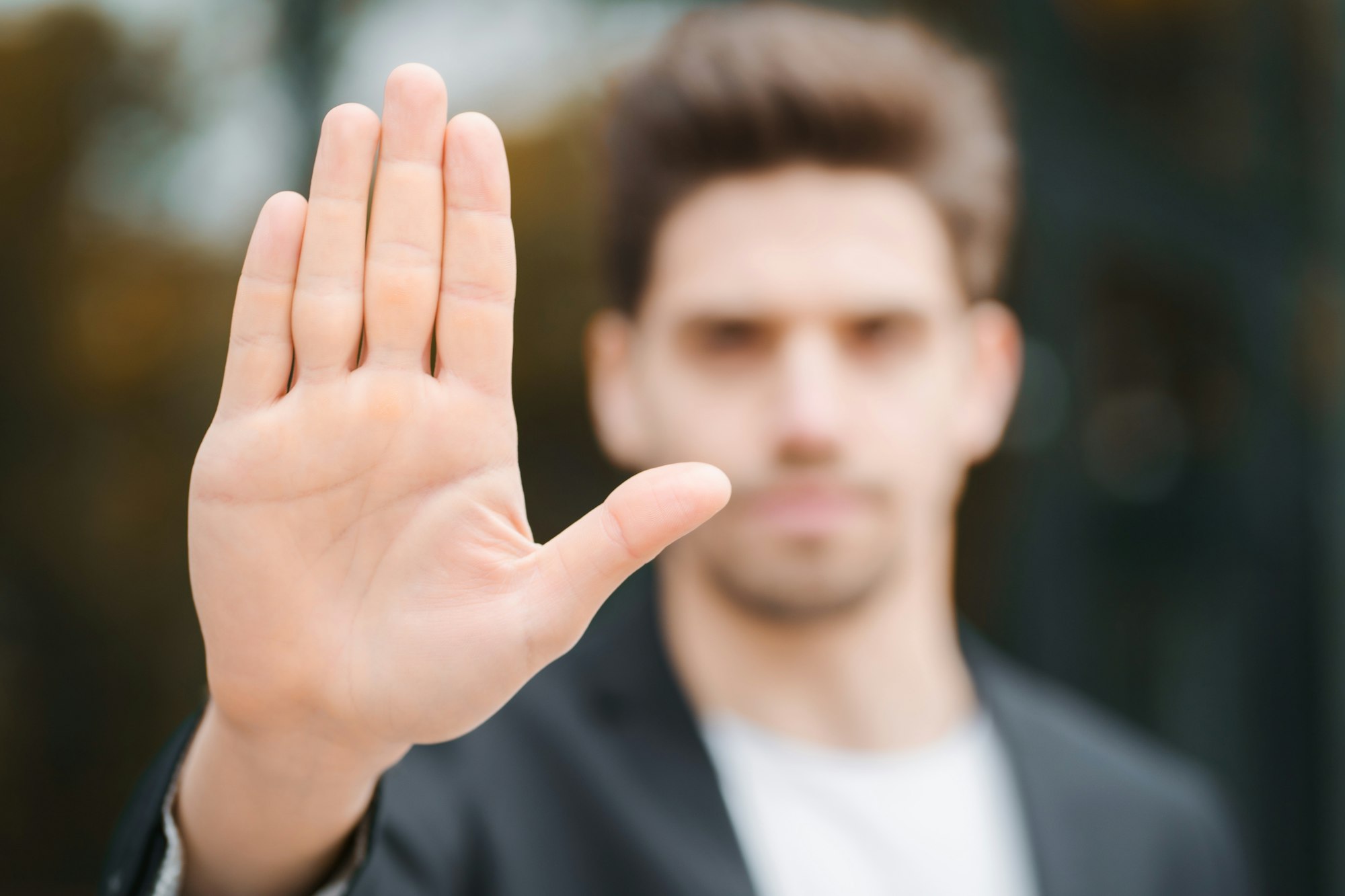 Portrait of young businessman disapproval gesture with hand: denial sign, no sign, negative