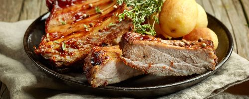 grilled pork ribs and potatoes on wooden table