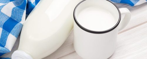 Milk cup and bottle on wooden table