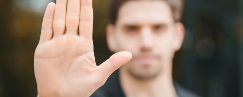 Portrait of young businessman disapproval gesture with hand: denial sign, no sign, negative