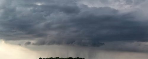 raining cloud over field in farmland